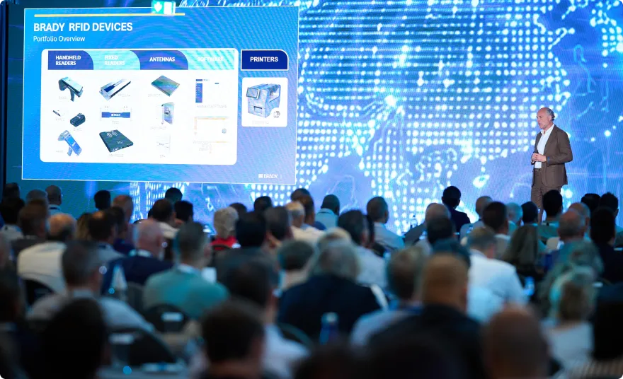 Speaker presenting traceability devices to a conference audience